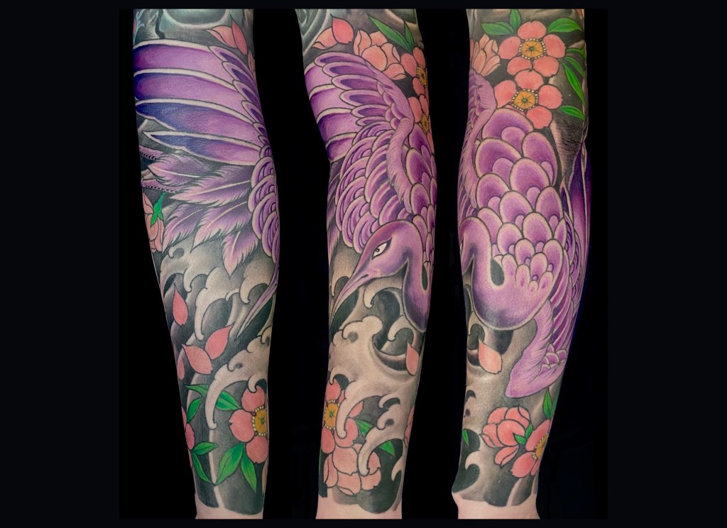 Japanese style arm sleeve. Beautiful detailed purple crane tattoo on a woman’s arm